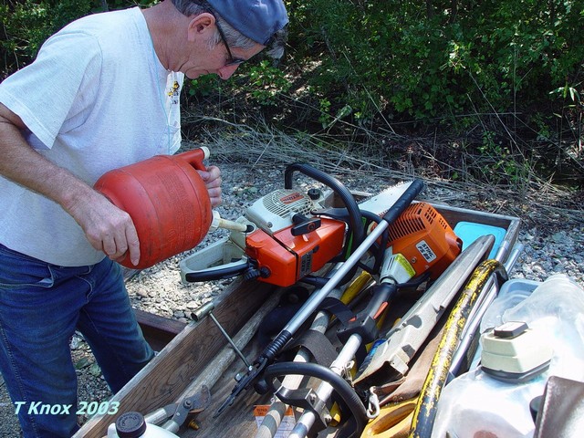Carey Boney fuels up the saw for more trees!